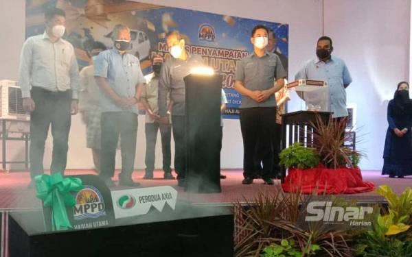 Aminuddin (tiga dari kiri) melihat hadiah cabutan utama berupa sebuah kereta Perodua Axia pada Majlis Penyampaian Cabutan Bertuah Cukai Taksiran MPPD di Port Dickson pada Jumaat.