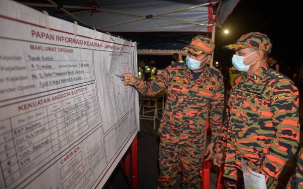Wan Md Razali mendengar penerangan daripada Ketua Unit Keselamatan Kebakaran JBPM Selangor PG KBII Mohd Hamizal Ainuddin di lokasi kejadian tanah runtuh di Jalan Kemensah Height, malam tadi. - Foto Bernama