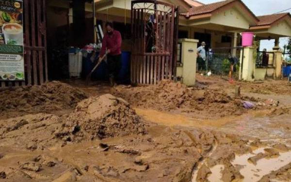 Seorang penduduk sedang membersihkan rumah di Taman Lembah Merbok yang dilanda banjir lumpur akibat fenomena kepala air. - Foto fail Sinar Harian
