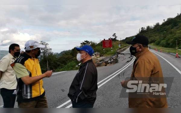 Saarani (tengah) mendengar penerangan Zulkipli berkaitan kejadian jalan runtuh di laluan Simpang Pulai - Blue Valley (Cameron Highlands).