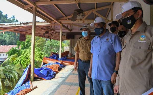 Menteri Tenaga dan Sumber Asli Datuk Seri Takiyuddin Hassan (dua, kanan) melihat kawasan rumah yang terjejas akibat kejadian tanah runtuh di Jalan Kemensah Heights hari ini. Turut hadir Ketua Pengarah Jabatan Mineral dan Geosains Malaysia Hisamuddin Termidi (kanan). - Foto Bernama