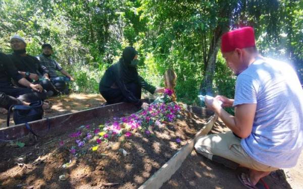 Nurina (kiri) bersama ahli keluarga selesai menyempurnakan upacara pengebumian Allahyarham Nilwan di Tanah Perkuburan Kampung Ulu Putatan, Putatan.