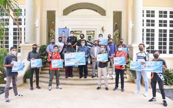 Aminuddin (tengah) bersama penghantar makanan yang menerima kad insurans Tabah di kediaman rasmi Menteri Besar di Seremban pada Isnin.