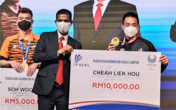 Presiden Persatuan Badminton Kuala Lumpur (KLBA), Datuk Seri Dr Jahaberdeen Mohamed Yunoos (kiri) menyerahkan mock cek kepada Liek Hou pada Majlis Meraikan Atlet dan Jurulatih Badminton Sukan Olimpik dan Paralimpik Tokyo 2020 di Akademi Badminton Malaysia pada Isnin. - Foto Bernama