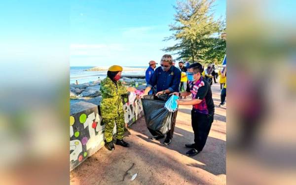 Mohd Huzaimy (tengah) menyertai Program Kempen Kebersihan anjuran Persatuan Kelab Belia Malaysia (MAYC) bagi mengutip sampah di Pantai Irama Bachok, Jumaat lalu. -Foto DUN Bachok