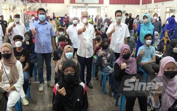 Wan Rosdy (tengah) bersama pelajar di Sekolah Menengah Kebangsaan Bukit Rangin yang menerima dos pertama vaksin Covid-19 pada Selasa.