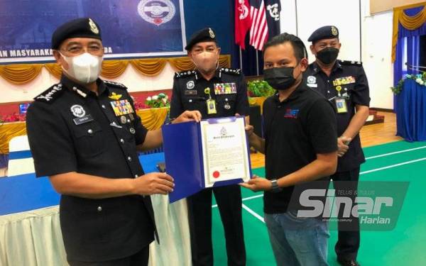 Shafien (kiri) menyampaikan sijil penghargaan kepada Mohd Hanif di IPD Kota Bharu pada Selasa. - Foto Sinar Harian