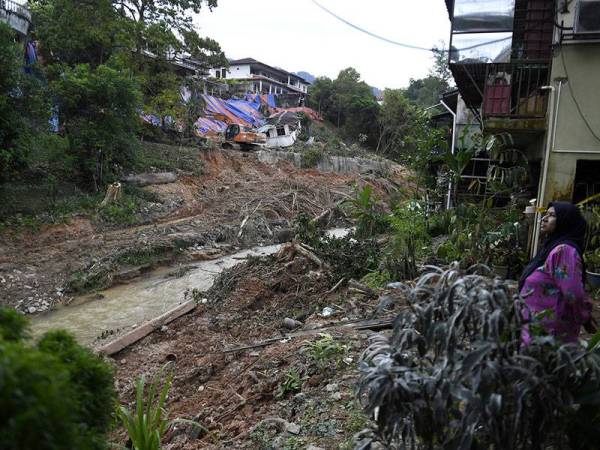 Beberapa penduduk sekitar meninjau kejadian tanah runtuh di bahagian belakang sebuah kediaman yang terjejas di Jalan Kemensah Heights pada Jumaat lepas ketika tinjauan sekitar jam 6 petang hari ini.