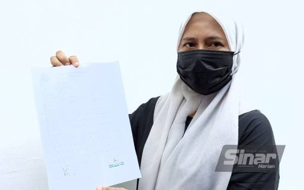 Rozina menunjukkan laporan polis yang dibuat pada Jumaat berhubung pencemaran sisa kimia di Kampung Baru Sri Aman, Seelong Kempas Johor Bahru.