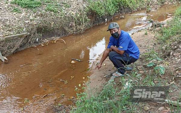 Abd Rahim menunjukkan anak sungai berdekatan rumahnya selepas seminggu insiden pencemaran bahan sisa kimia di Kampung Baru Sri Aman, Seelong Kempas Johor Bahru.