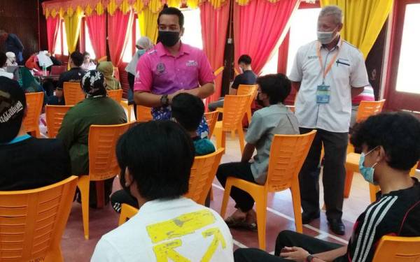 Ahmad Saidi (kanan) ketika meninjau pelaksanaan program Vaksin Anakku di SMKA Sultan Azlan Shah pada Khamis.