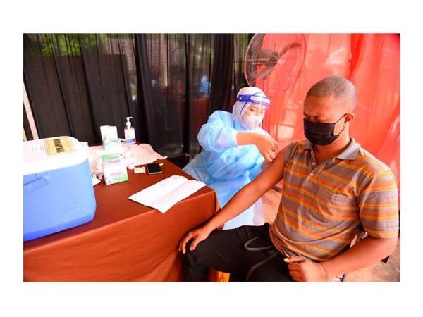 Petugas KKM memberikan suntikan vaksin kepada salah seorang penduduk orang asli dari Gua Musang.