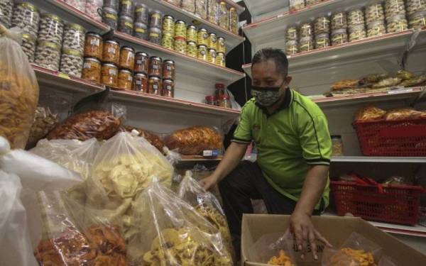 Pekerja kedai kerepek Plaza Angsana Johor Bahru menyusun pelbagai jenis kerepek di kedainya susulan negeri Johor beralih ke fasa 2 Pelan Pemulihan Negara (PPN) ketika tinjauan hari ini.- Foto Bernama