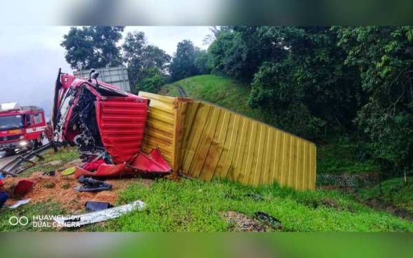 Keadaan lori jenis Isuzu yang terbabas dan terbalik di bahu jalan. - Foto ihsan Bomba