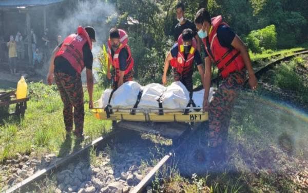 Anggota bomba mengangkat mayat mangsa sebelum diserahkan kepada pihak polis.