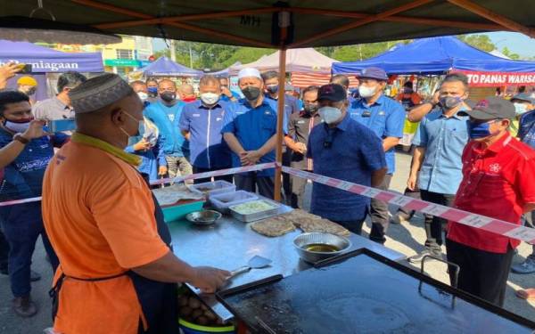 Muhyiddin bertanya khabar peniaga ketika mengadakan lawatan ziarah penduduk dan peniaga di Taman Pagoh Jaya, Pagoh, Muar pada Sabtu.