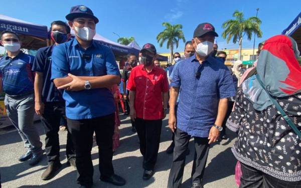 Muhyiddin (tengah) dan Sahruddin (kiri) mengadakan lawatan ziarah penduduk dan peniaga di Taman Pagoh Jaya, Pagoh, Muar pada Sabtu.