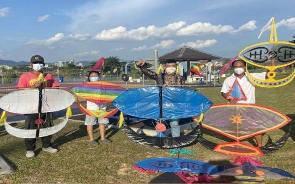 Chin Seong (dua dari kanan) bersama rakan Tionghua lain menjadikan permainan wau tradisional yang terkenal dalam kalangan orang Melayu sebagai hobi ketika melakukan aktiviti beriadah hampir setiap petang di Taman Rekreasi Sungai Chua, Kajang. - Foto Bernama