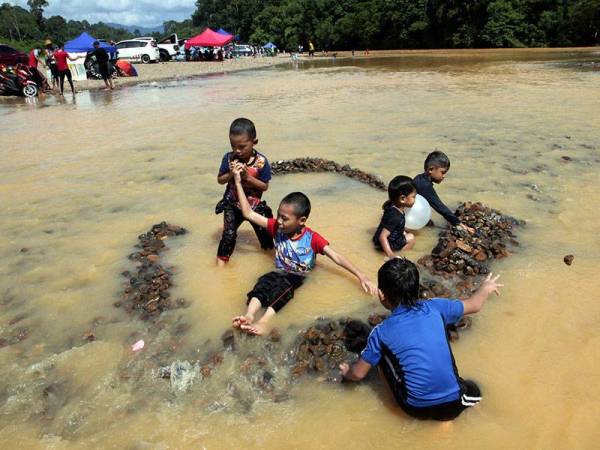 Kanak-kanak bersaudara seronok bermain air sungai di kawasan rekreasi dan perkelahan Pasir Puteri hari ini.