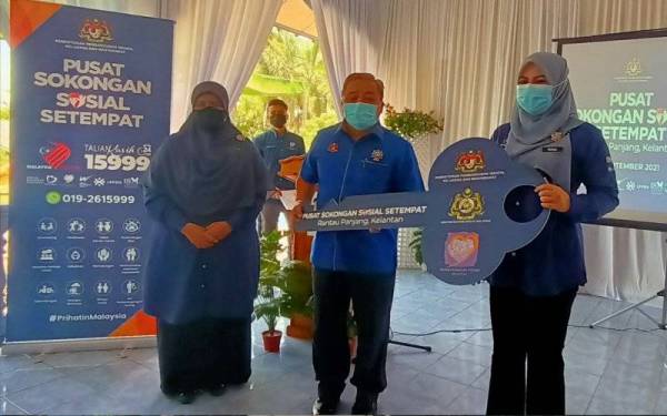 Rina (kanan) menerima penyerahan replika kunci daripada Rakbi (dua dari kiri) sebagai simbolik penyerahan di Kompleks Perumahan Kastam Rantau Panjang, pada Ahad.