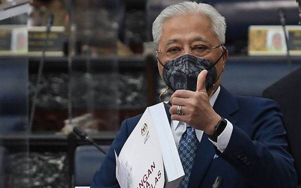 Perdana Menteri Datuk Seri Ismail Sabri Yaakob menunjukkan buku 'Rancangan Malaysia Kedua Belas' (RMK12) selepas membentangkan RMK12 di Bangunan Parlimen hari ini. Foto Bernama