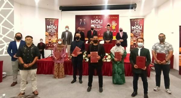 Wan Roslan (belakang, tiga dari kanan) semasa hadir merasmikan memorandum persefahaman Stesen Mek Awey di Tunjong pada Isnin.