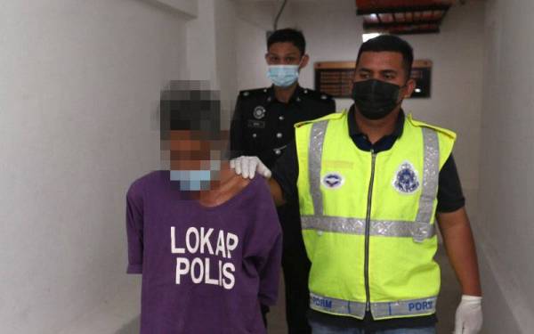 Tertuduh (kiri) yang berusia berusia 61 tahun dikawal polis berjalan menuju ke Mahkamah Sesyen Kota Bharu pada Selasa untuk berdepan tuduhan melakukan amang seksual terhadap seorang kanak-kanak perempuan berusia tujuh tahun yang juga anak kepada rakannya.