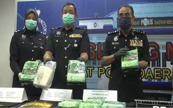 Abdul Majid (kanan) menunjukkan bekalan dadah jenis syabu bernilai lebih RM200, 000 yang dirampas dalam serbuan pada Ahad lalu