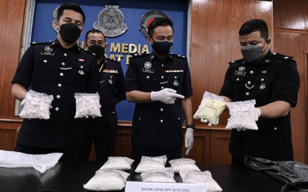 Kamarul Rizal (dua dari kanan) menunjukkan bungkusan dadah heroin yang dirampas semasa mengadakan sidang akhbar di Ibu Pejabat Polis Daerah Barat Daya di sini hari ini. - Foto Bernama