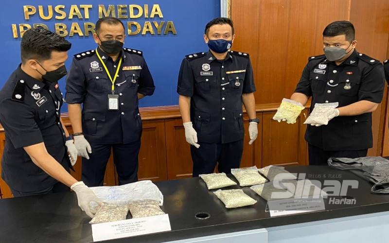 Kamarul (dua dari kanan) bersama pegawai penyiasat menunjukkan dadah yang dirampas.