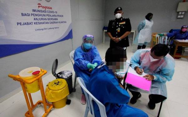 Fayrouz memerhati seorang banduan menerima suntikan vaksin Covid-19 daripada petugas Jabatan Kesihatan Daerah Kuantan pada Program Imunisasi Covid-19 bagi penghuni Penjara Penor. - Foto Bernama