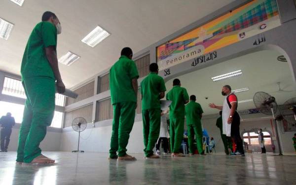 Banduan berbaris menunggu giliran untuk divaksin oleh petugas Jabatan Kesihatan Daerah Kuantan pada Program Imunisasi Covid-19 bagi penghuni Penjara Penor. - Foto Bernama