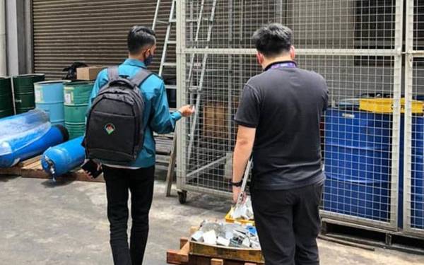 Anggota JAS Johor (kiri) melakukan pemantauan di salah sebuah kilang yang dikompaun menerusi operasi di Kawasan Perindustrian Desa Cemerlang pada Rabu.