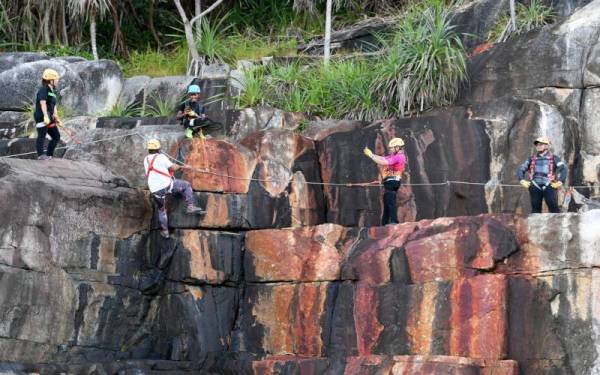 Peserta-peserta melalui trek mendaki lereng bukit di Pulau Lang Tengah yang bakal menjadi tarikan terbaharu untuk peminat sukan ekstrem berlatar belakang Laut China Selatan. Trek yang dikenali sebagai 'via ferrata' bermaksud 'laluan besi' dalam bahasa Itali merupakan trek khas di permukaan bukit, gunung atau gua menggunakan alat keselamatan yang lengkap untuk pendaki tiba ke puncak dengan lebih mudah. - Foto Bernama