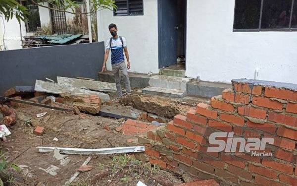 M Prakash menunjukkan tembok rumah yang runtuh akibat banjir kilat di Jalan Belumut, Taman Johor, Kempas, Johor Bahru.