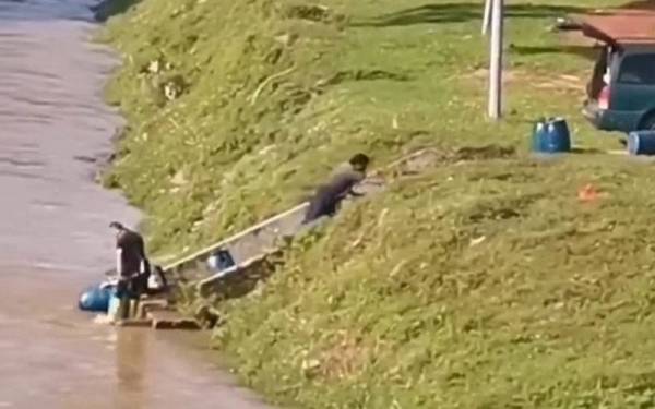 Tangkap layar tiga individu dirakam sedang melepaskan anak ikan dan bukan membuang sisa ke Sungai Kinta. -Foto ihsan pembaca