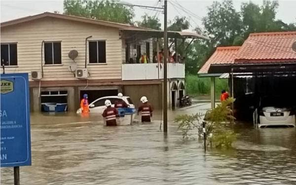 Pasukan bomba memindahkan mangsa banjir kilat di Kampung Rancha-Rancha Darat, Labuan.