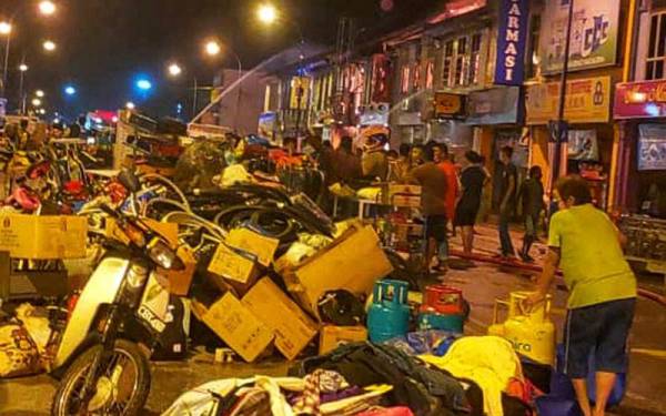 Orang ramai mengeluarkan barangan milik mereka di tepi jalan. - Foto laman sosial