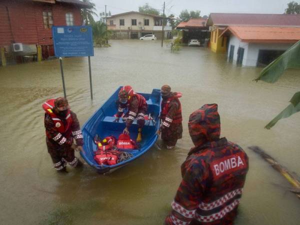 Anggota Jabatan Bomba dan Penyelamat Malaysia (JBPM) Labuan ketika bertugas di kawasan banjir di Kampung Rancha-Rancha hari ini.