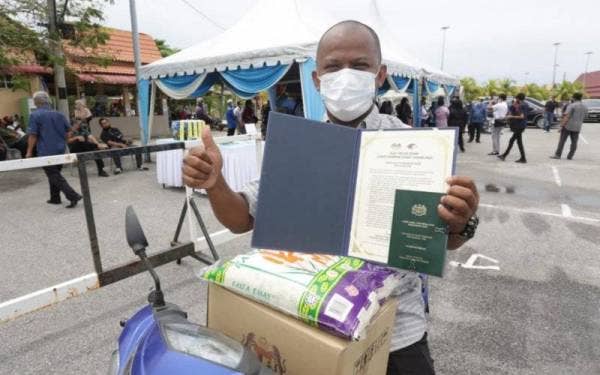 Salah seoarang penerima bantuan Sijil sampan khas nelayan menunjukan sijil yang diterimanya.