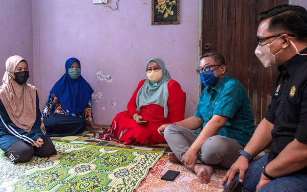 Wan Khairul Ihsan (kanan) hadir bagi menyampaikan sumbangan kewangan daripada Perdana Menteri kepada pelajar Wan Nur Atierah Wan Mohd Nasrom, 19, di rumahnya di Kampung Bendang Pulau Palekbang hari ini. -Foto Bernama