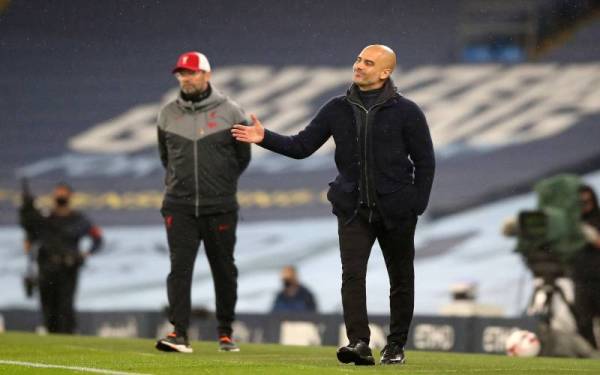 Guardiola (kanan) mempertaruhkan rekod pertemuan kedua-dua kelab menjelang kunjungan ke Anfield pada Ahad. FOTO: AFP