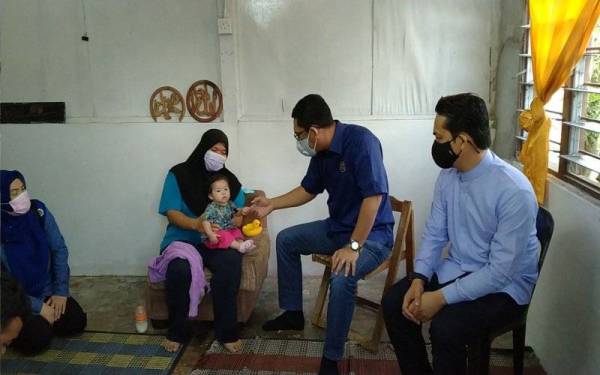 Ahmad Faizal (dua dari kanan) menziarahi seorang ibu tunggal, Norhayati Abdul Rahim, 39, di Kampung Manjoi, Ipoh pada Ahad.
