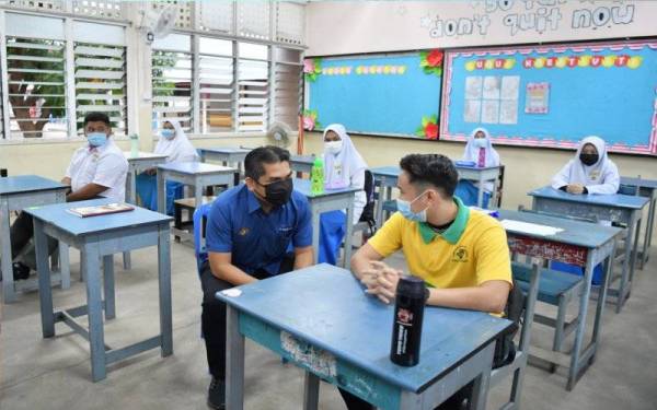 Mohd Radzi (kiri) bertanya khabar pelajar SMK Sultan Sulaiman di Kuala Terengganu yang memulakan sesi persekolahan pada Ahad.