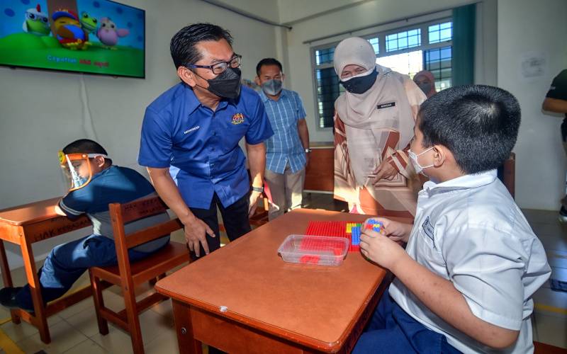 Timbalan Menteri Pendidikan II Mohamad Alamin (kiri) beramah mesra dengan salah seorang murid istimewa ketika lawatan kerja ke Sekolah Kebangsaan Pendidikan Khas Matang Jaya pada Isnin. - Foto Bernama