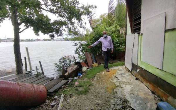 Ahmad Adenan menunjukkan hakisan ban yang sangat hampir dengan kediaman penduduk Rancangan Perkampungan Tersusun (RPT) Kampung Raja Bashah, Kuala Kurau, di sini.