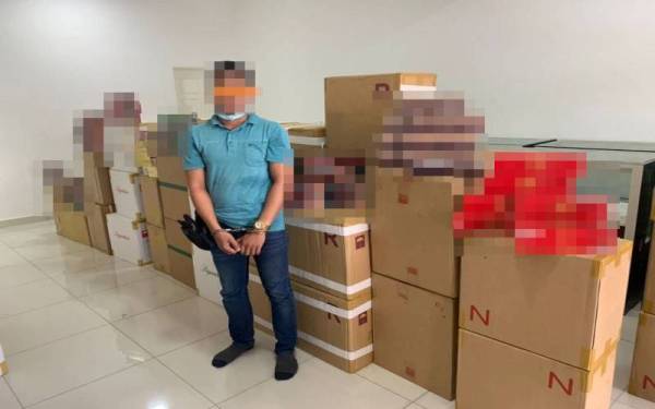 Seorang lelaki ditahan bersama 4,223 karton rokok seludup yang dirampas dalam satu serbuan di Serdang pada Selasa. (Mohon blurkan gambar dan rokok)