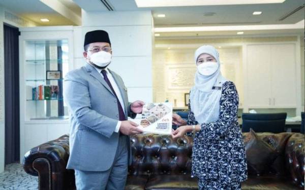 Noor Hadina menyerahkan laporan tahunan Jabatan Pendakwaan Syariah Wilayah Persekutuan kepada Ahmad Marzuk. - Foto FB Ahmad Marzuk
