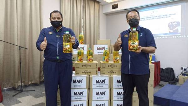 Sallawudin (kiri) dan Eddlie ( kanan) menunjukkan minyak masak keluaran LPP Johor.