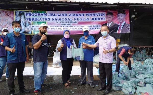 Abu Bakar (dua kanan) menyampaikan sumbangan kepada ketua-ketua cawangan Bersatu, Pas dan Parti Gerakan pada Program Jelajah Ziarah Prihatin PN di Bandar Baru Uda, Johor Bahru, pada Jumaat.